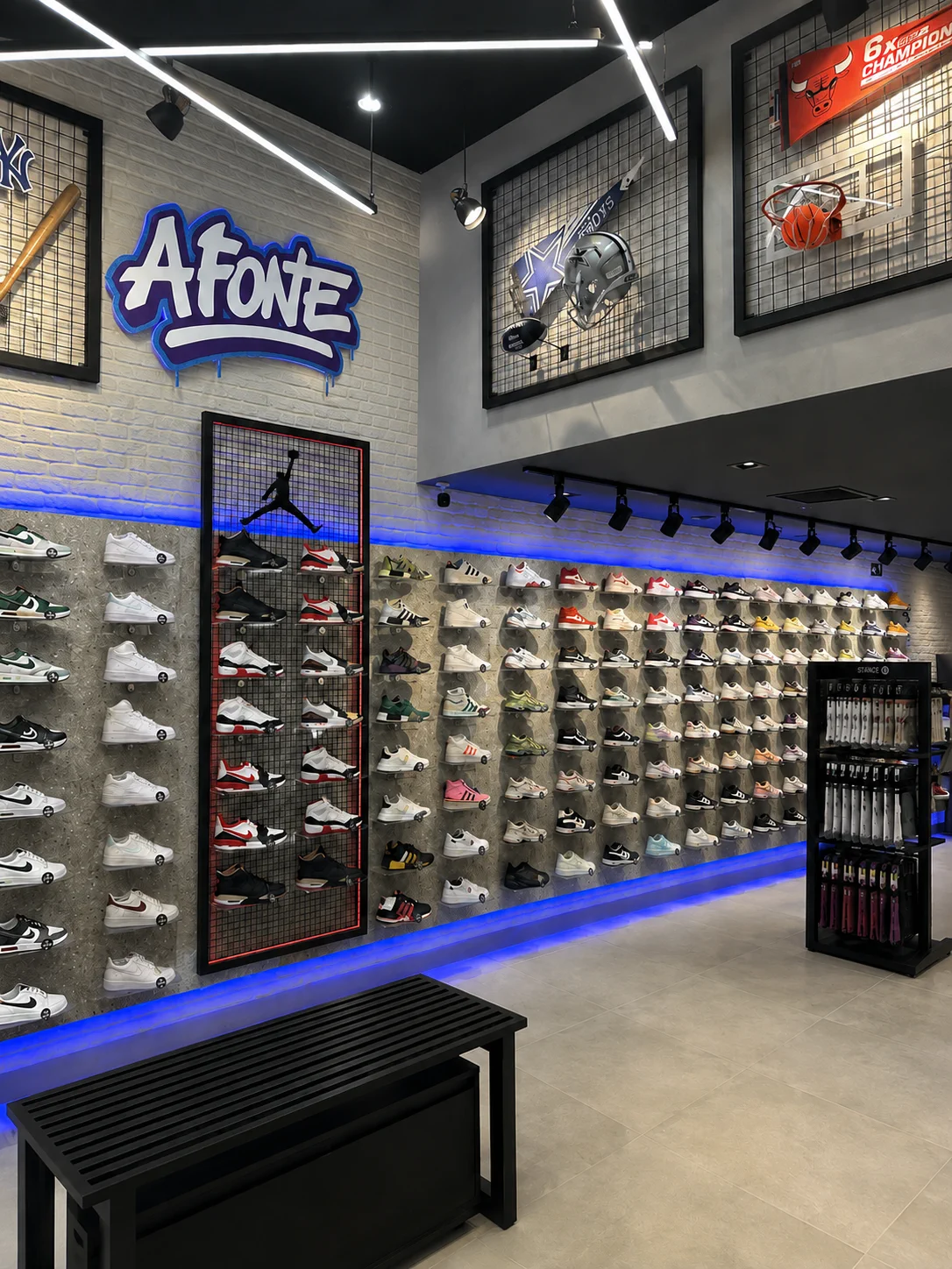 Por dentro da loja A Fonte Sneakers: parede de tênis e o letreiro da marca